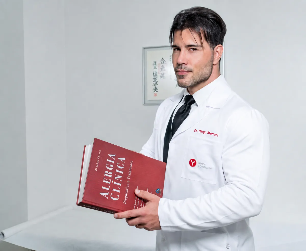 Dr. Diego Marroni, alergista em Porto Alegre, de jaleco segurando o livro Alergia Clínica